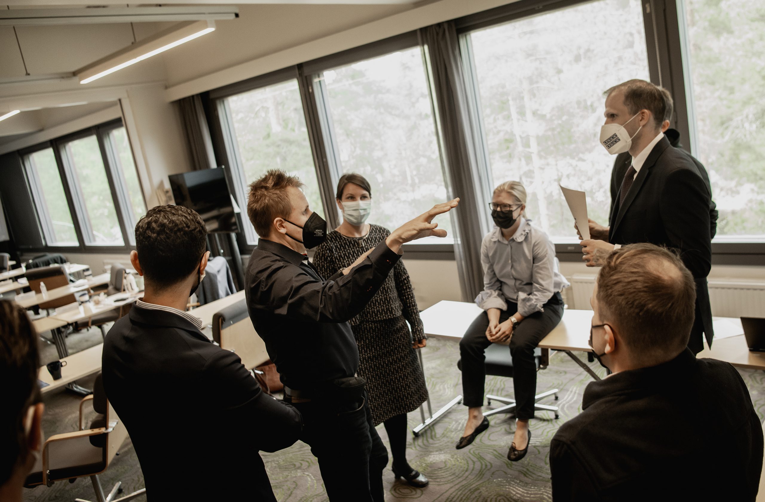 People standing in a cricle and discussing in a room during mediation course